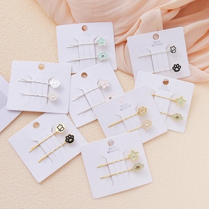 Detalle de horquillas para el pelo con estrellas, nubes y garras de gato en tarjeta
