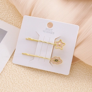 Detalle de pinzas para el cabello con estrella rosa y nube en tarjeta de exhibición