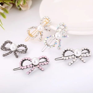 Set of five elegant rhinestone bowtie hair clips featuring large pearls and gold finish