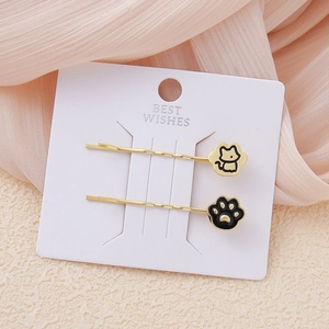Elegantes pinzas de pelo doradas con diseños de gatos y huellas en esmalte negro