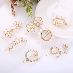 Detail of elegant gold hair clips set with sparkling rhinestones and artificial pearls