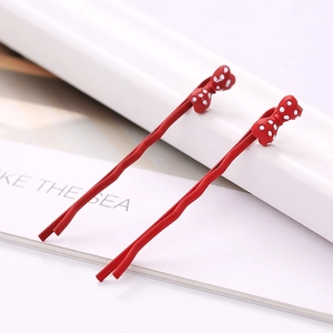 Gros plan de barrettes à nœud rouge à pois avec structure en métal dans un ensemble de 2