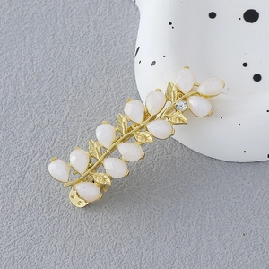 Pince à cheveux feuille dorée avec pierres œil de chat et fleur en cristal brillant