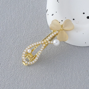 Barrette à cheveux dorée avec perles blanches et fleurs en œil de chat jaune sur fond gris