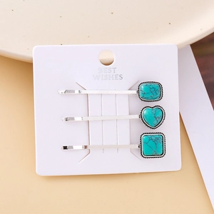 Detailed view of turquoise hair clips set with heart and geometric patterns on gift card
