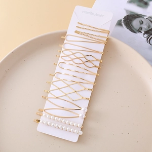 Lot de 16 barrettes à cheveux minimalistes dorées avec perles sur une assiette en céramique