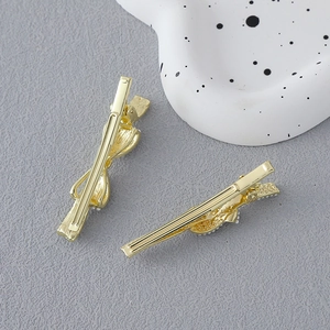 Close-up of golden bow hair clips with metallic texture on a decorative tray