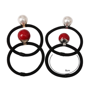 Close-up of elastic hair ties with pearls and red beads measuring 6cm in diameter