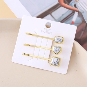 Three-piece turquoise hairpin set with gold finish and heart pattern on gift card