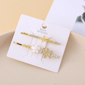 Close-up of golden floral hair clips with cat-eye flowers, rhinestones and pearls