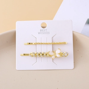 Detail of gold butterfly hair clips with mother-of-pearl wings and small crystals