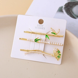 Chinese style hair clips set with bamboo pearls and green enamel on gold metal finish