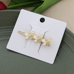 Exquisite golden hair clip featuring three white resin butterflies with crystal accents