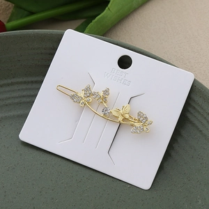 Elegant golden butterfly hair clip with white rhinestones on premium display card