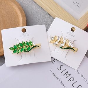 Elegant wheat leaf hair clips with green crystals and pearls on a gold-plated base