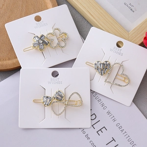 Detail of floral and heart hair clips with crystals on a white display card