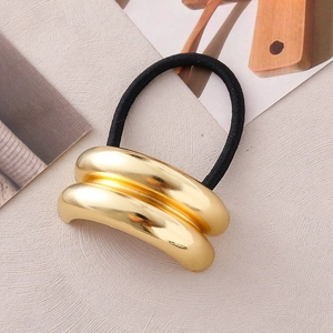 Detailansicht der goldenen Doppelbogen-Klammer am schwarzen elastischen Haarband im Punk-Stil