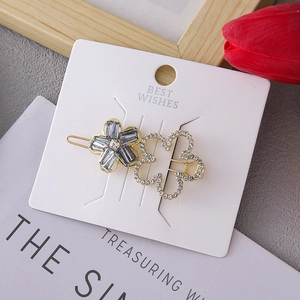 Elegant floral hair clips with grey crystals and white rhinestones on display card