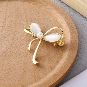 Barrette à cheveux nœud doré avec pétales en nacre et perle sur plateau en bois