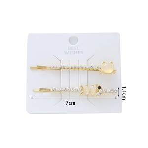 Détail de barrettes dorées 7cm avec fleur en pierre chat et design arête strass