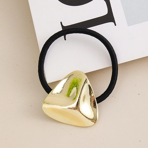 Detail of a black elastic hair tie with a polished gold irregular triangle metal charm