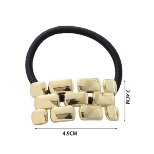 Close-up of golden metal hair tie showing 4.9cm by 2.4cm dimensions on white background