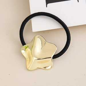 Detail of a golden star-shaped metallic charm on a black high-elastic hair scrunchie