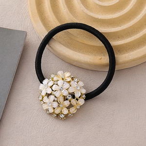 Élastique cheveux élégant avec fleurs nacrées blanches et strass sur base dorée chic