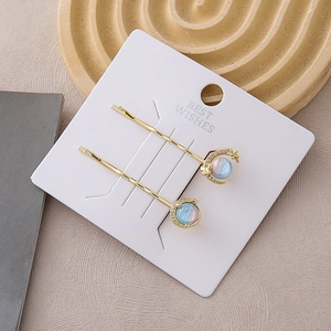 Detailed close-up of crescent moon and planet hair clips with small rhinestones