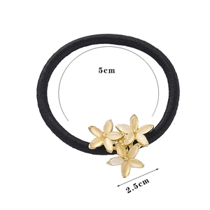 Détail d'un élastique noir de 5cm avec des fleurs en œil de chat crème de 2,5cm