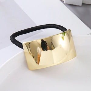 Detailed view of irregular curved gold metal plate on a thick black elastic hair tie