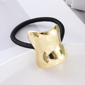 Minimalist black elastic hair tie with a curved gold-tone polished metal charm