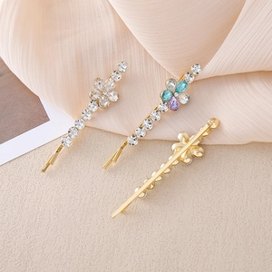 Detalle de tres pinzas de flores con brillantes cristales y base de aleación de oro fino