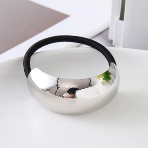 Macro view of silver curved metal piece on a flexible black elastic hair tie