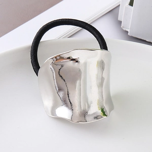 Detail of minimalist irregular wavy silver metal ornament on a black elastic hair tie