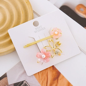 Elegant cherry blossom hair clip set with pink petals, gold metal, and pearl accents