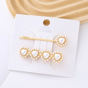 Ensemble de barrettes dorées avec cœur en perles et pince sur carte d'affichage