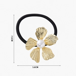 Dettaglio di un elastico per capelli a fiore dorato con perla da 7,5 cm per 5,6 cm