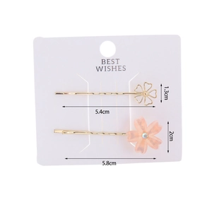 Detail of two-piece cherry blossom hair clip set with golden metal and resin petals