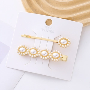 Ensemble de barrettes dorées avec fleurs de perles blanches sur carte minimaliste