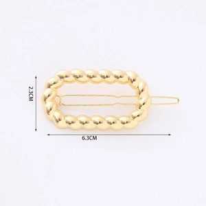 Detail view of a 6.3cm gold geometric hair clip featuring a hollow rope twist design