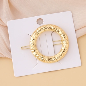 Minimalist gold round geometric hair clip with hammered texture and metal finish
