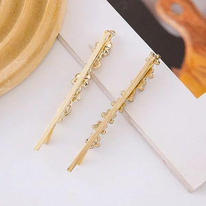 Detail view of two gold butterfly metal bobby pins for hair on a white decorative card