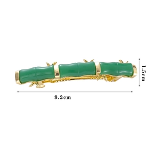 Detailansicht der 9,2 cm grünen Bambus-Haarspange mit goldenen Blattakzenten und Metallfuß