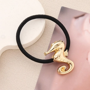Détail d'un élastique à cheveux hippocampe en alliage doré minimaliste sur un support