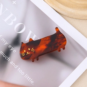 Close-up of a tortoiseshell cat hair clip made of premium acetate on a white paper background