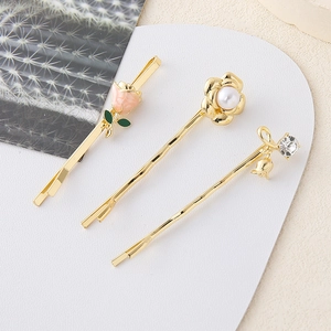Detalle de pinzas para el cabello con rosas y lirios, decoradas con perlas y strass