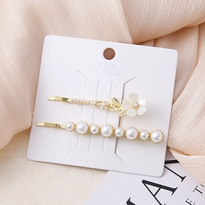 Elegante set van twee parel haarspelden met bloemmotief en gouden afwerking voor dames