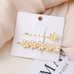 Elegante bloemen haarklemmen set met goud metaal en gele harsbloemen op een kaart