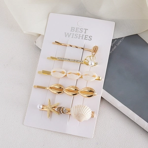 Lot de barrettes marines avec perles, coquillages et étoiles de mer sur présentoir